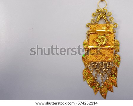white background and weaving golden fabic decorated with sequin and bead call Tung Lanna, northern thailand art at right side