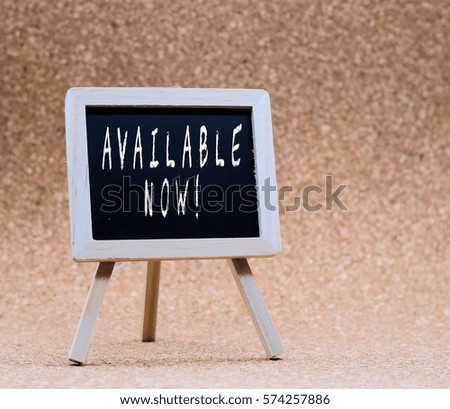 Stand blackboard written "AVAILABLE NOW" with brown background.