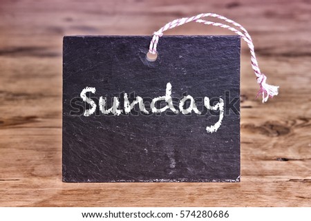 the word Sunday written on chalk board on wooden table