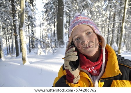 Hiker talking on smartphone in winter mountains. Concept of success living and free traveling. Beautiful winter landscape with snow. woman