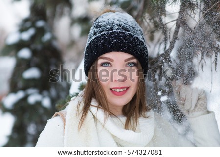 Beautiful young woman wearing merino wool pastel colors hat morning outdoors. Skin Care, Lip care, care of the eyelashes in the winter season. Beauty young woman Having Fun in Winter Park.