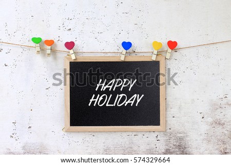 Happy Holiday - Concept words on the blackboard hanging with rope on rustic wooden background