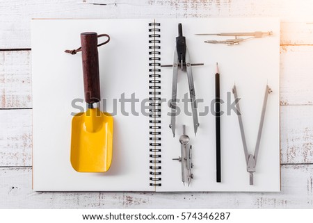 house deisgn concept with drawing tool on notebook and vintage wood background
