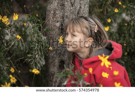Little girl in yellow autumn flowers