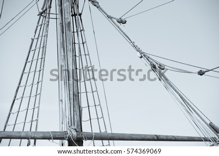 Vintage filtered image  of mast of old ancient historic wooden sailing yacht, with rigging and ropes, sky and copy space.