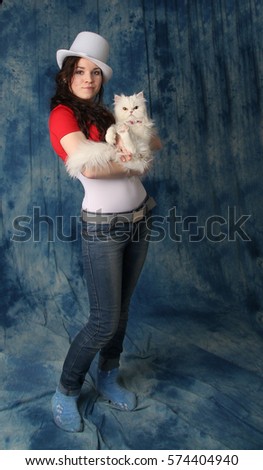 Girl in a white hat with a white cat on a blue background