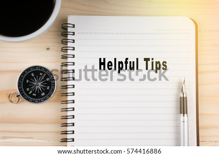 Notebook written with HELPFUL TIPS word on wooden background. Business Concept.