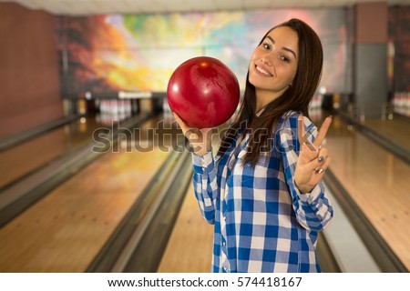 Peace everyone! Young beautiful woman smiling holding a bowling ball showing peace or victory sign with two fingers posing at the bowling club copyspace leisure gesture two victory sign symbol sports 