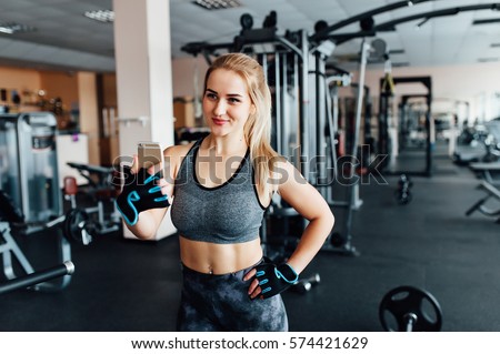 young beautiful sporty woman making selfie photo on smart phone in gym