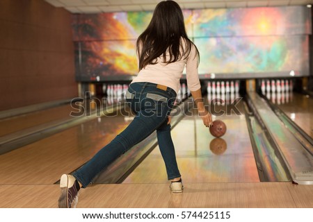 Rolling the ball. Rearview full length shot of a woman playing bowling at the club bowling ball rolling on the bowling alley towards bowling pins copyspace entertainment fun weekend game player 