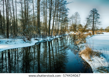 Landscape - sundown or sunset in Suprasl river valley. Winter time in Knyszynska Forest, North - Eastern part of Poland, Europe.