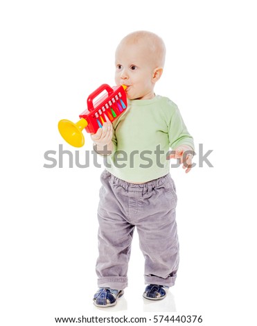 Funny toddler boy playing with musical toy isolated background