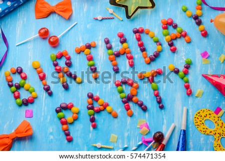 Diagonal Birthday Party sign on the blue background. Orange bows, red lollipops, confetti and noisemakers. Create a party to remember.