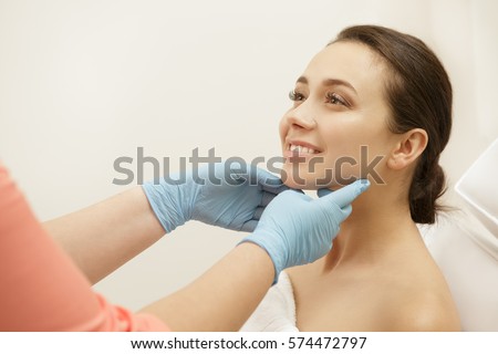 Beauty treatment results. Beautiful healthy cheerful woman smiling while her cosmetologist is examining her skin happiness vitality cosmetology beauty professional clinic spa center client copyspace Royalty-Free Stock Photo #574472797