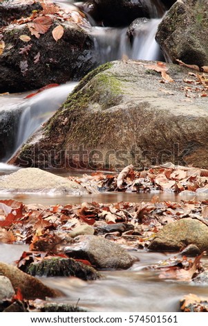 great wonders of nature - soft misty river waterfall in forest in autumn winter season - long exposure
