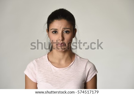 young beautiful hispanic sad woman serious and concerned looking worried and thoughtful facial expression feeling depressed isolated grey background in sadness and sorrow emotion  Royalty-Free Stock Photo #574517179