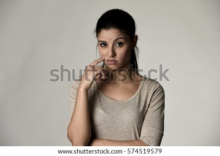 young beautiful arrogant and moody spanish woman showing negative feeling and contempt facial expression isolated on grey background looking cocky and defiant 