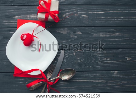 Valentine's Day. red felt heart ,plate,fork and knife on wooden background Royalty-Free Stock Photo #574521559