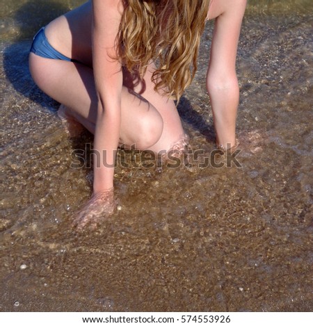Unknown woman with slender body on sea beach 