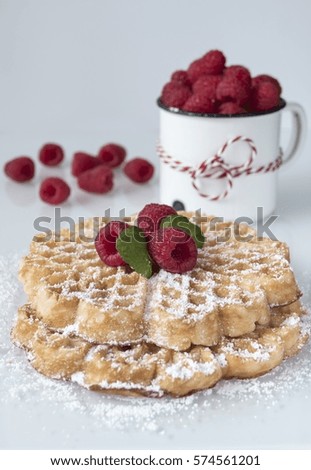 Homemade waffles and raspberries in a vintage cup