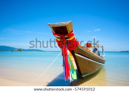 FISHERMAN LONG-TAIL BOAT ANCHORED NEARBY SANDY BEACH , CLEAR SEAWATER AT ISLAND SEASIDE , BEAUTIFUL BLUE SKY SUNNY DAY BACKGROUND 