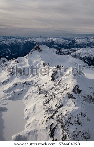 Aerial landscape view of the beautiful snow covered mountains of British Columbia, Canada. Picture taken in the mountain range north of Vancouver, BC.
