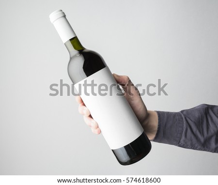 Hand is holding wine bottle