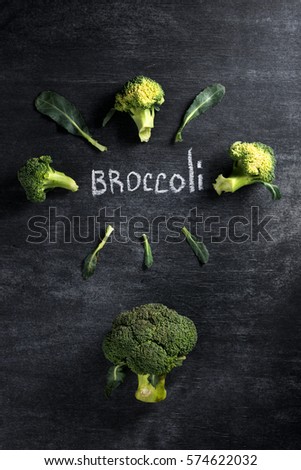 Top view picture of broccoli over dark chalkboard background.