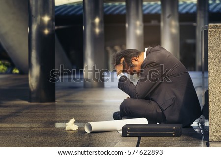 Sad Asian businessman losing job, depressed employee people who's employment. Alcoholic Entrepreneur sit on floor with anxiety, upset, worried, stressed and lonely after know rate of jobless is high.  Royalty-Free Stock Photo #574622893