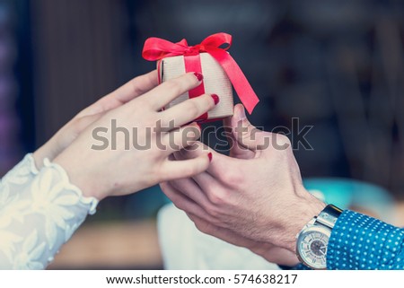 Hands of a Man and Woman Holding Present