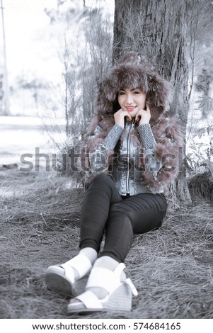 Portrait of beautiful woman in winter cloths at pine forest