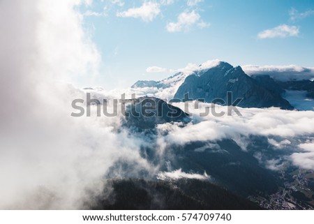 Creamy fog covered the glacier Marmolada in morning light. Great and gorgeous scene. Location place Val di Fassa valley, passo Sella, Dolomiti, Tyrol. Italy, Europe. Beauty world. Drone photography.
