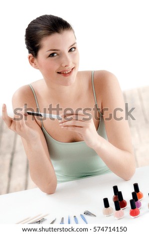 Portrait of beautiful young woman with nail file in bedroom