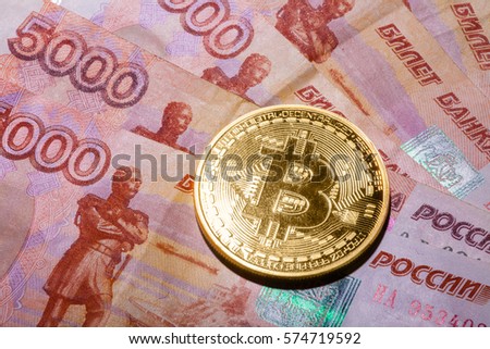 One Bitcoin on Russian banknotes. Closeup, macro shot
