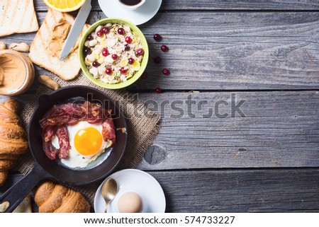 Breakfast including coffee, fried egg , croissant, orange juice , muesli and bread .