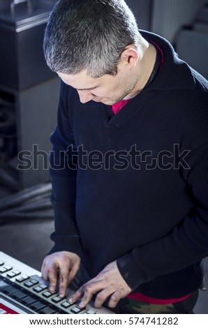 Young man in the process of offset printing and color correction