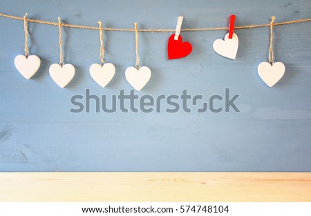 Valentines day background. hearts hanging in front of blue background. With wooden floor. product display backdrop