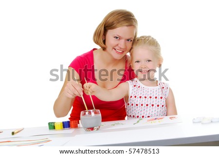 Photo of mother and daughter painting with aquarelle and looking at camera