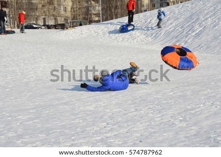 Dad and kid slid down a snow hill on snow tube
