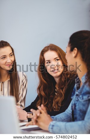 Creative businesswomen discussing at desk in office