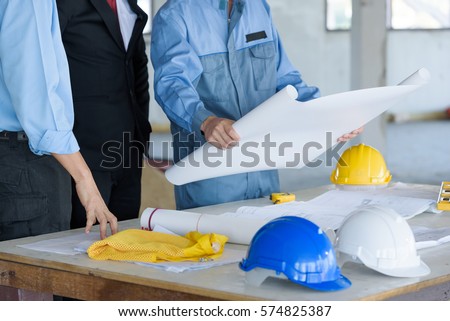 Project Plan construction engineer worker meeting a new strategic safety security  with blueprint plan, working with partner and engineering tools on workplace Royalty-Free Stock Photo #574825387
