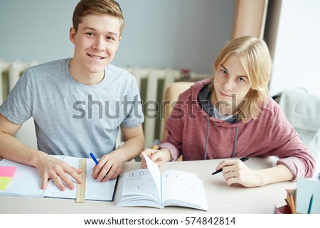 Two guys drawing design pictures in copybooks