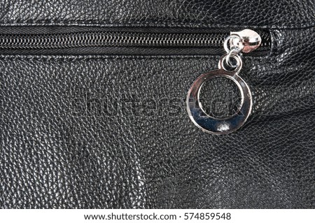 closeup of buckles, clasps, zippers, pockets, fasteners, fittings and seams on the black leather hand bag