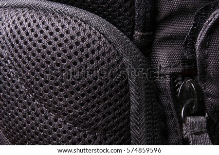 closeup of breathable mesh fabric, buckles, clasps, zippers, pockets, fasteners, fittings and seams in the black photo backpack