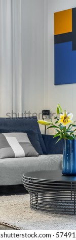 Vertical panorama of cozy living room with sofa and openwork coffee table with flowers in vase