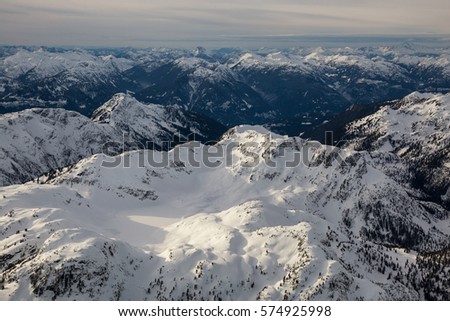 Aerial view of the snow covered mountain in British Columbia, Canada. Picture taken north of Vancouver, BC, during a cloudy winter day.