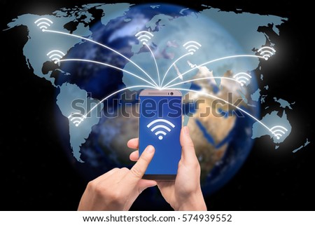 Hand holding smart phone on world map network and wireless communication network, abstract image visual, internet of things.Elements of this image furnished by NASA Royalty-Free Stock Photo #574939552
