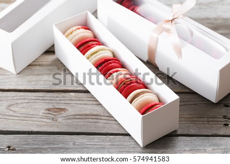 Red macaroons desserts on wooden background. dessert for breakfast on Valentine's Day