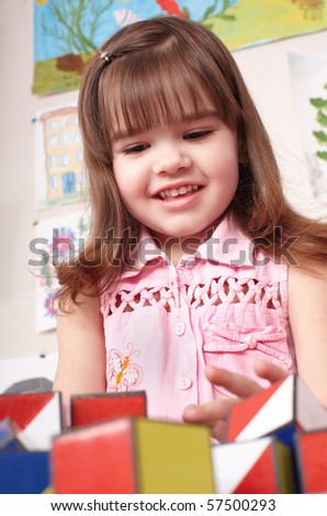 Little girl  playing with  block  in  room. Preschool.