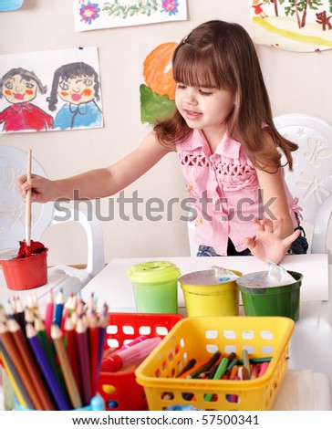 Little girl paint picture in preschool.